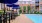 a pool with tables and chairs next to it and umbrellas by it