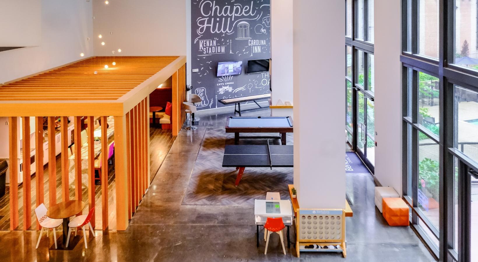 Settle into comfort at Berkshire Chapel Hill a room with tables and chairs