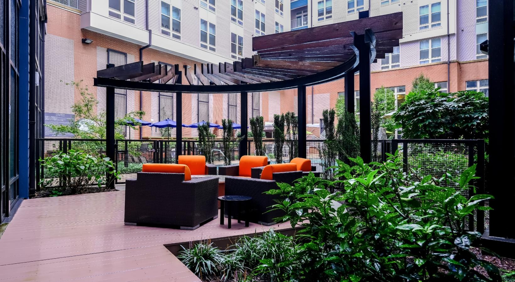 Access to resident-only features a patio with a table and chairs and plants by a building