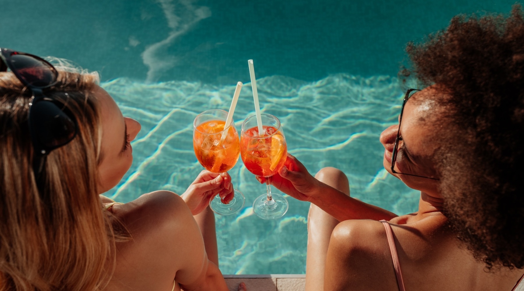 two women by the pool with drinks