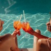 two women by the pool with drinks