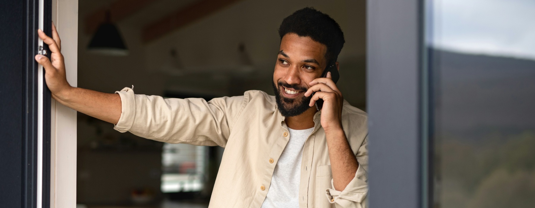 man standing in a doorway on the phone