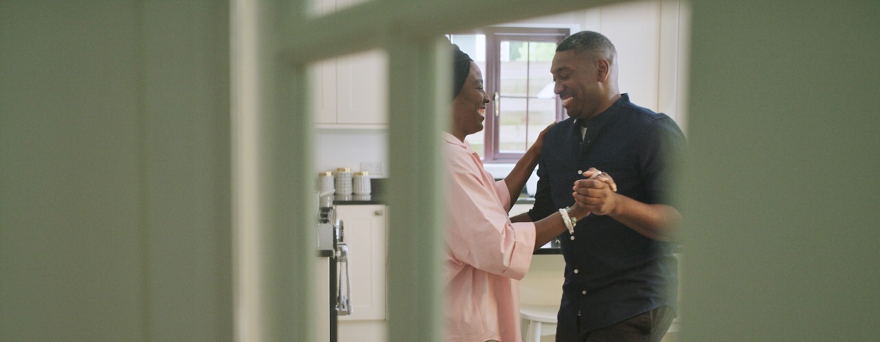 a couple dancing in a kitchen
