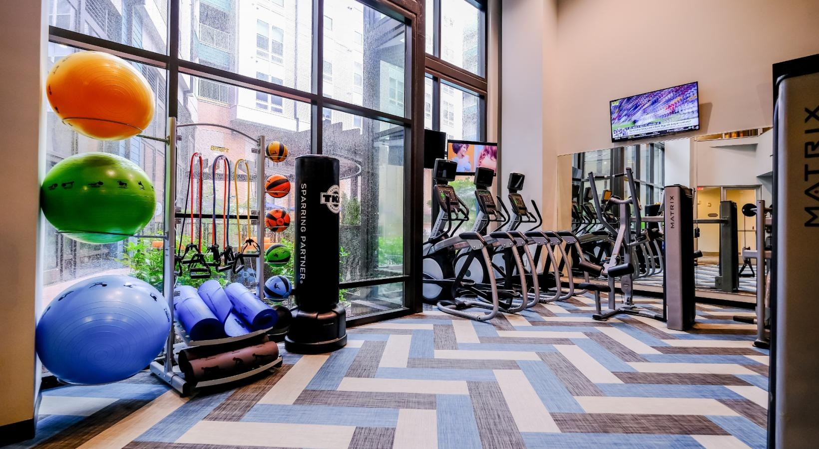 Quick access to state-of-the-art amenities fitness center with large windows and exercise equipment
